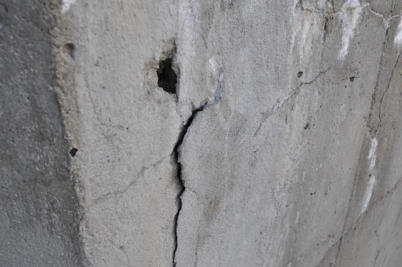 Pęknięty wylany beton, ślady po wilgoci i być może przymrozek uszkodziły jego strukturę.