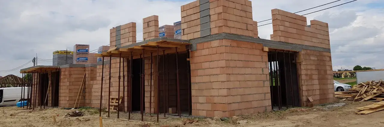 Budowa domu z pustaków ceramicznych, porowaty materiał budowlany, tworzy solidne ściany.