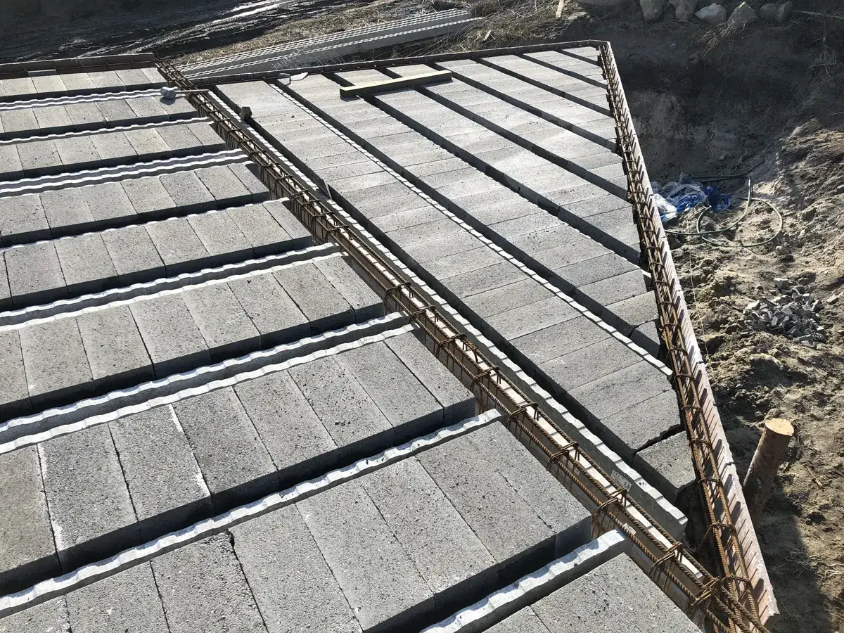 Budowa stropu gęstożebrowego Teriva. Betonowe pustaki i zbrojenie czekają na zalanie betonem.