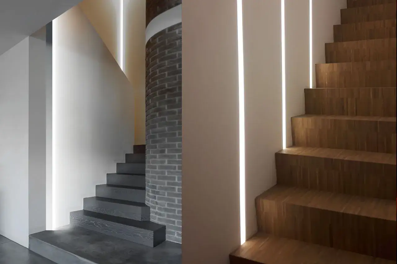 Nowoczesne schody z drewnianymi stopniami i betonową posadzką. Elegancka osłona ściany przy schodach z pionowym podświetleniem LED.